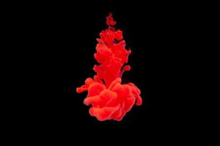 Red ink in water isolated on black background